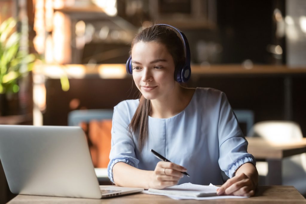 capacitação online - menina com fone de ouvido olhando para o computador