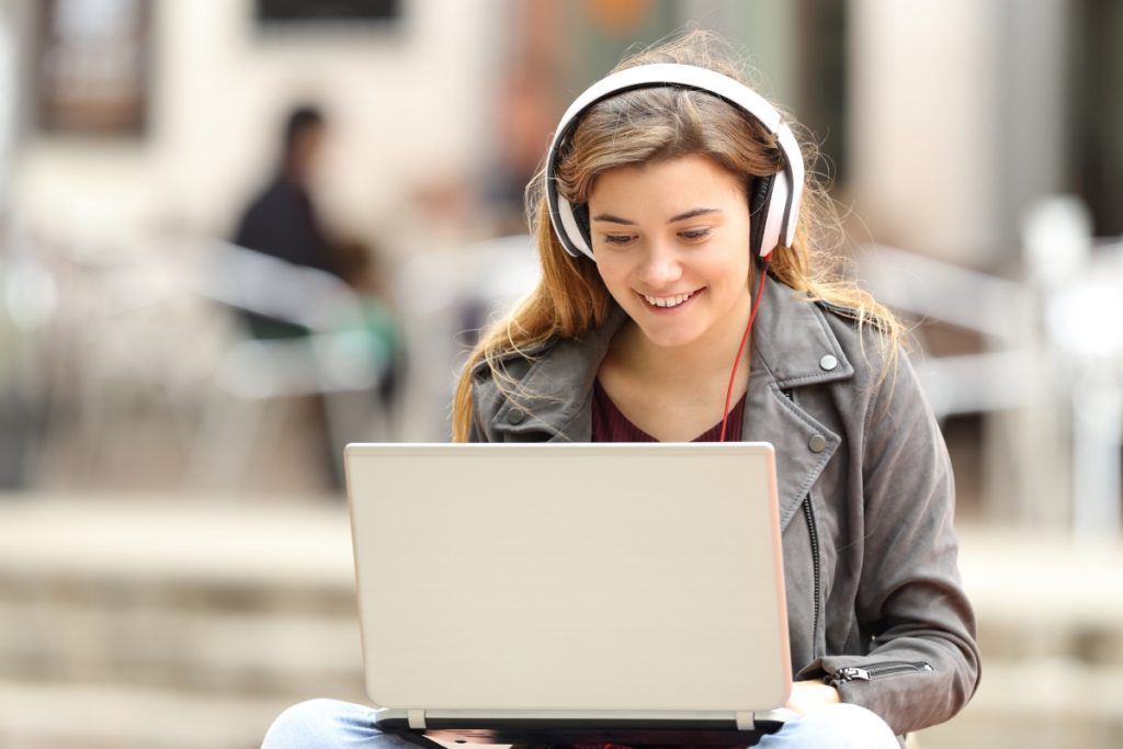 ferramentas digitais - menina mexendo no computador sorrindo