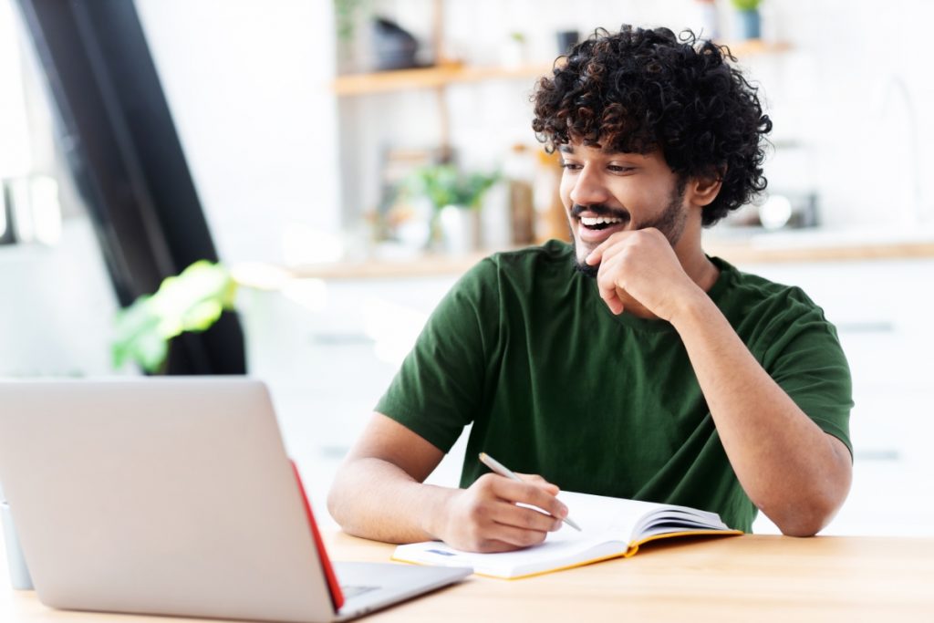 aula remota - jovem sorrindo para o computador